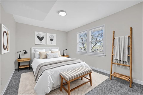 A bedroom with a large bed and a wooden bench at Highland Ridge Apartments, Capitol Heights, Maryland