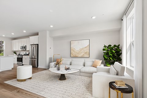 A modern living room with a white sofa, a coffee table, and a large painting on the wall.