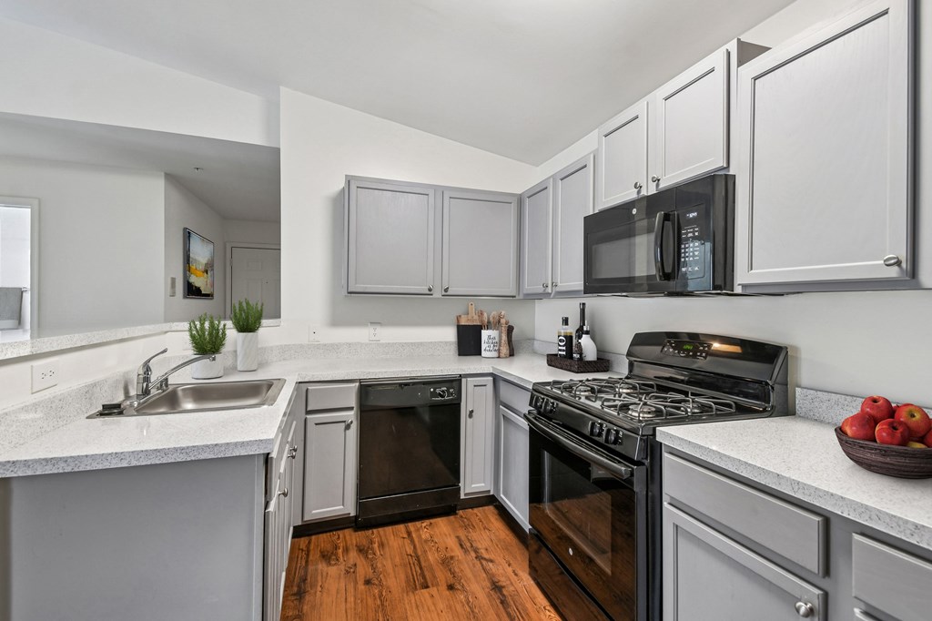 A modern kitchen with a black stove top oven and a black microwave above the stove.