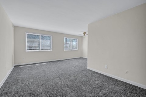 A room with grey carpet and two windows at Highland Ridge Apartments, Capitol Heights, MD