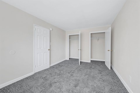 A room with a carpeted floor and two doors at Highland Ridge Apartments, Capitol Heights, MD, 20743