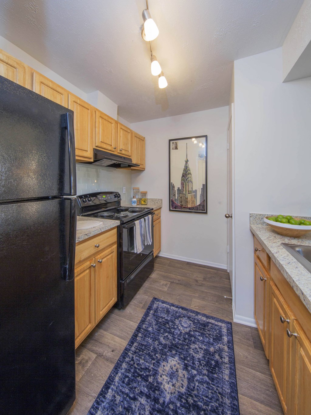 a kitchen with a black refrigerator freezer next to a stove top oven at Madison at Eden Brook, Maryland