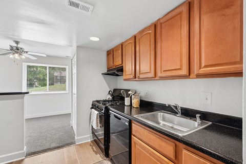 A kitchen with black countertops and wooden cabinets.