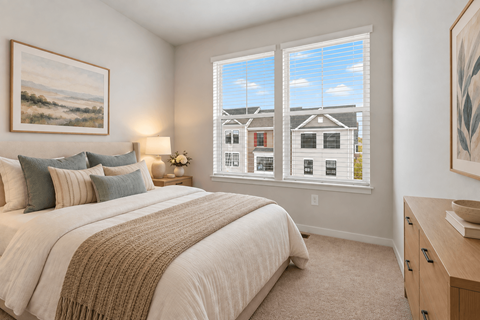 A bedroom with a large bed and a painting on the wall.
