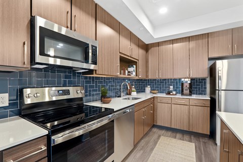 a modern kitchen with black appliances and wood cabinets