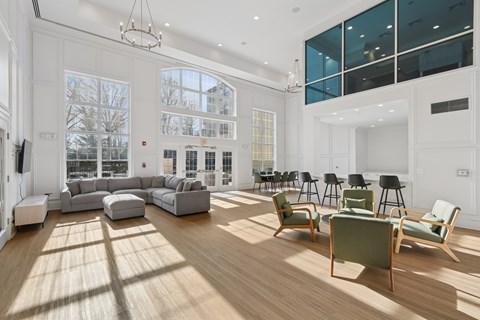 A living room with a large sectional sofa and a wooden floor.