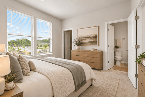 A bedroom with a large bed, a window with a view of the outside, and a painting on the wall.
