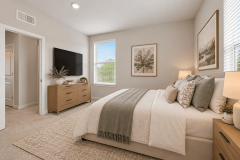 A bedroom with a large bed and a flat screen TV mounted on the wall.