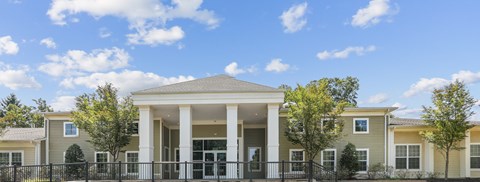 A row of houses with a black fence in front.
