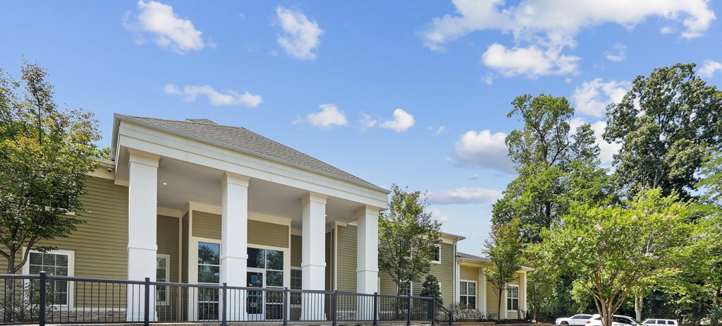 A house with a black fence and white columns.