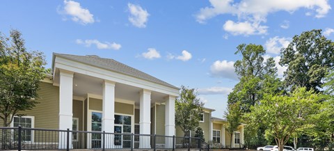 A house with a black fence and white columns.