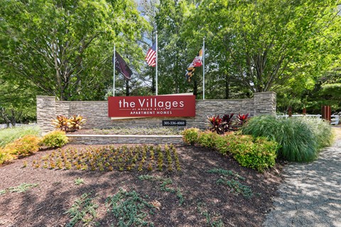 a sign for thevillages yards with flags and trees at Villages at Morgan Metro, Landover, MD, 20785