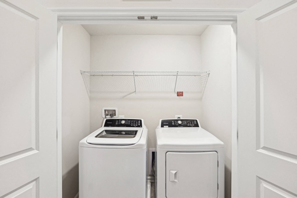 an empty laundry room with two washes and a dryer at Refinery Row, Baltimore, MD 21224