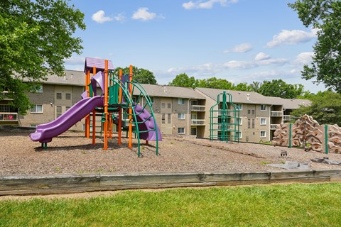 Colorful playground with climbing wall and mulch surface at The Brook At Columbia Apartments, Columbia, MD