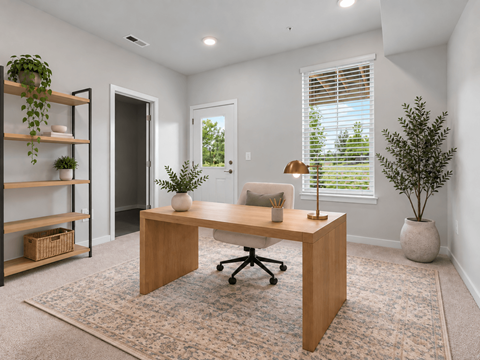 A room with a desk, chair, and potted plants.