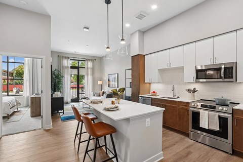 A modern kitchen with a white island and wooden cabinets.