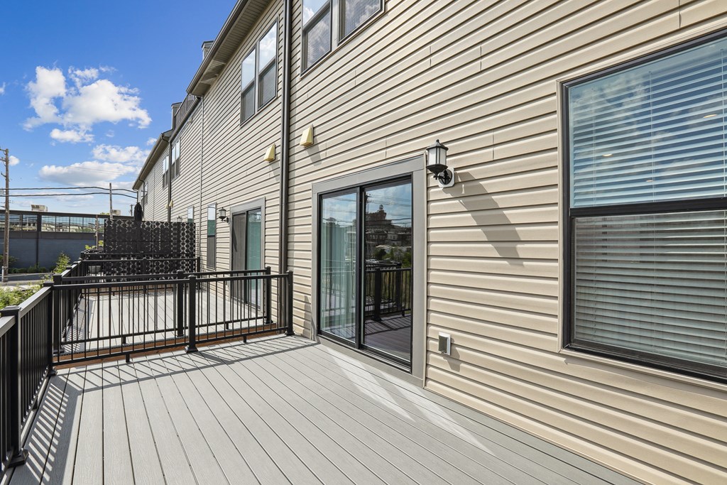 the deck of a home with a large window and a balcony at Refinery Row, Baltimore, Maryland