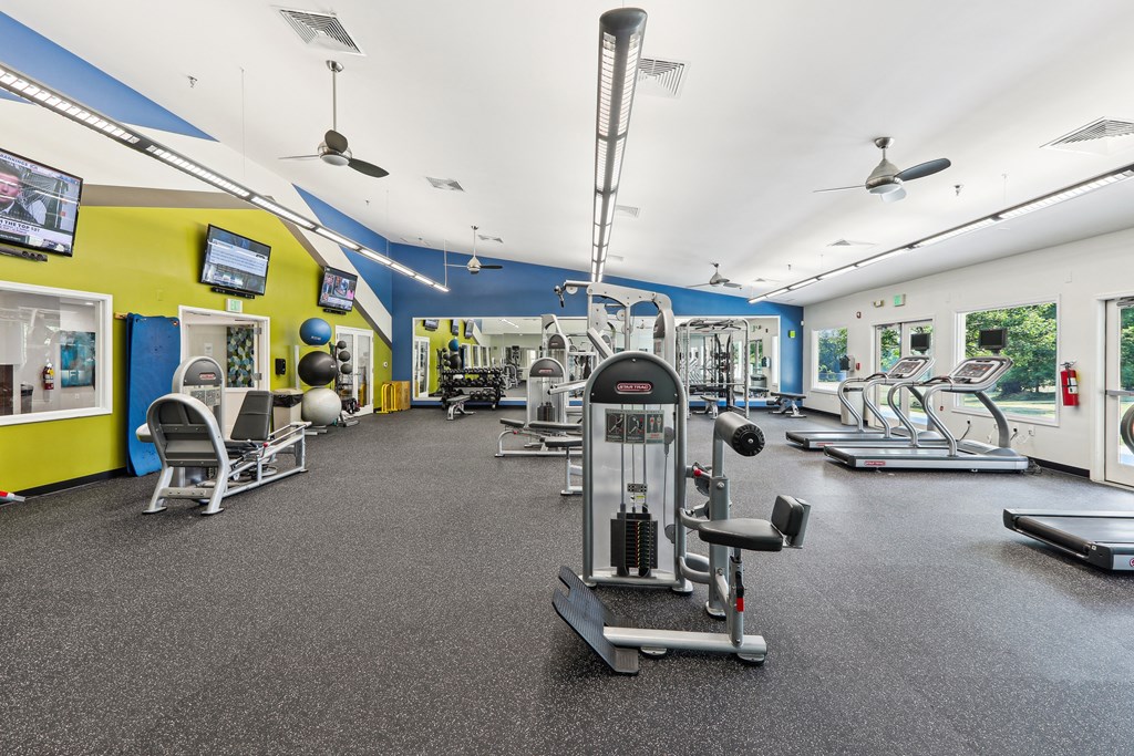 a gym with weights and cardio equipment on the floor and walls with yellow and blue at Villages at Morgan Metro, Landover, Maryland, 20785