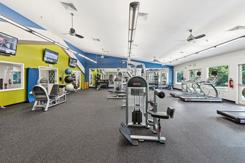 a gym with weights and cardio equipment on the floor and walls with yellow and blue at Villages at Morgan Metro, Landover, Maryland, 20785