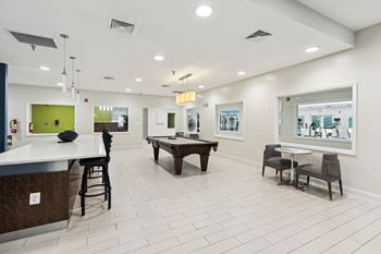 a game room with a pool table and a bar at Villages at Morgan Metro, Landover, 20785