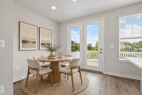A dining room with a round table and chairs.