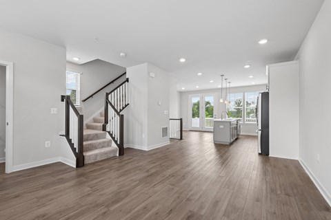 A spacious living room with a staircase leading to the upper floor.