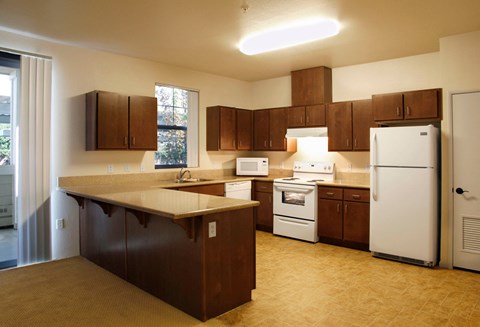 a kitchen with brown cabinets and white appliances and a counter top