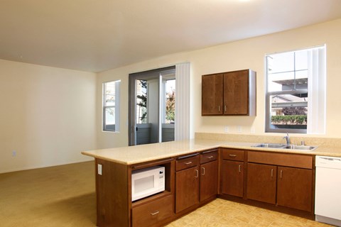 an empty kitchen with wooden cabinets and a microwave