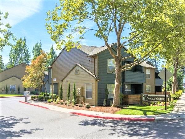 a green and brown house on the corner of a street