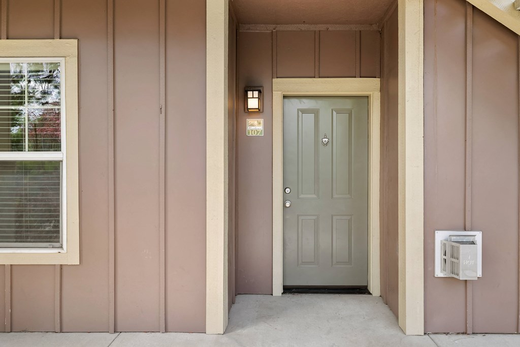 the front door of a pink house with a grey door