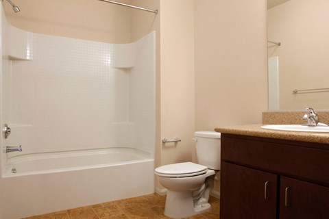 a bathroom with a toilet and a tub and a sink