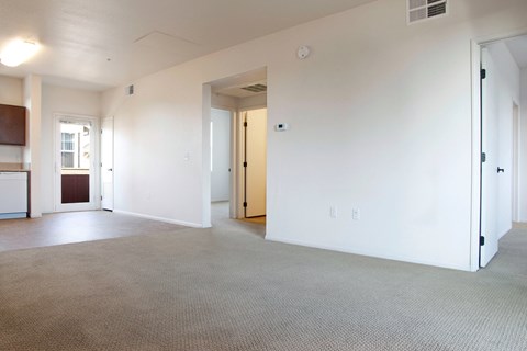 the living room of an empty apartment with white walls and carpet