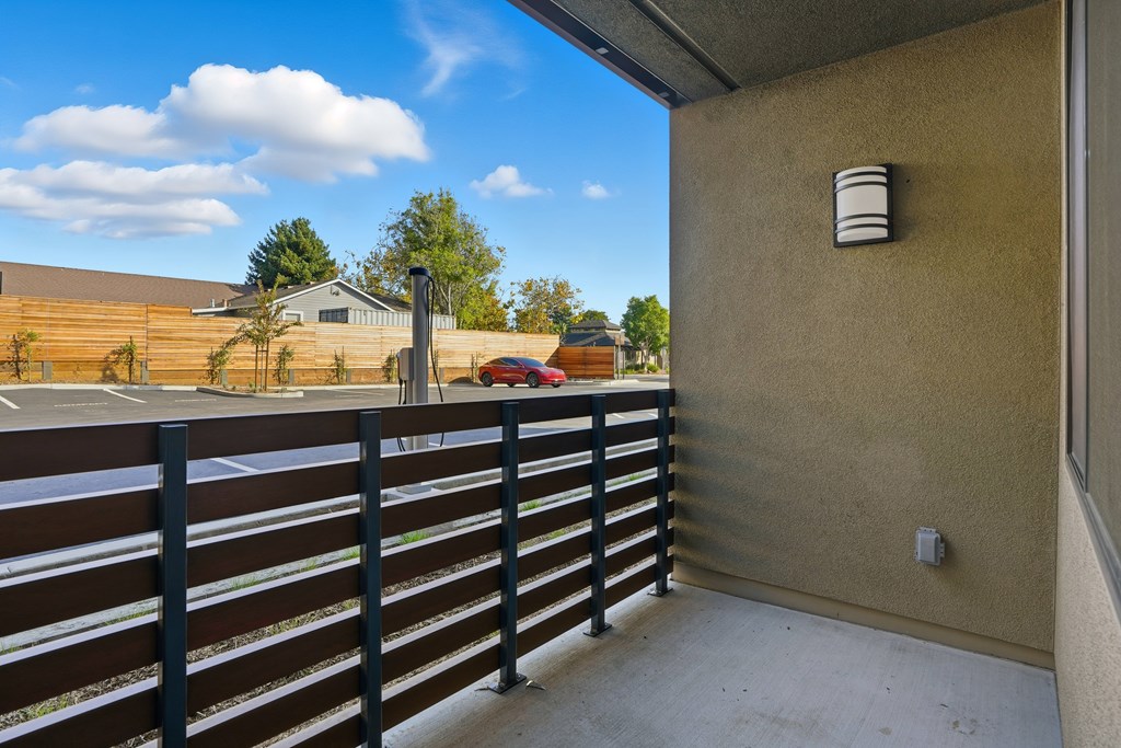 A balcony with a black railing and a wall-mounted air conditioning unit.