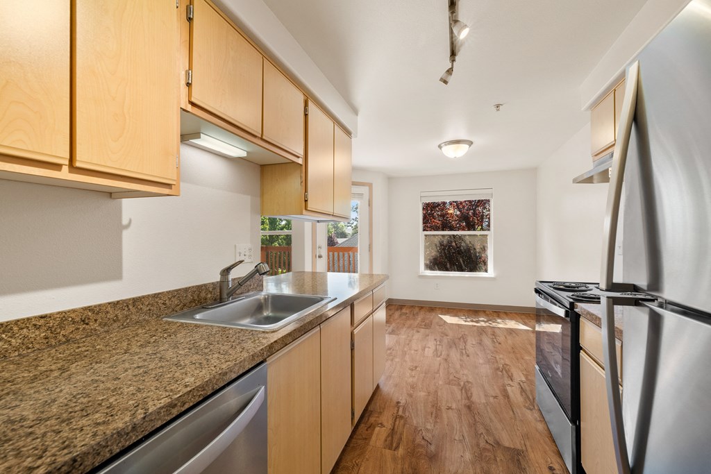 an empty kitchen with granite counter tops and stainless steel appliances