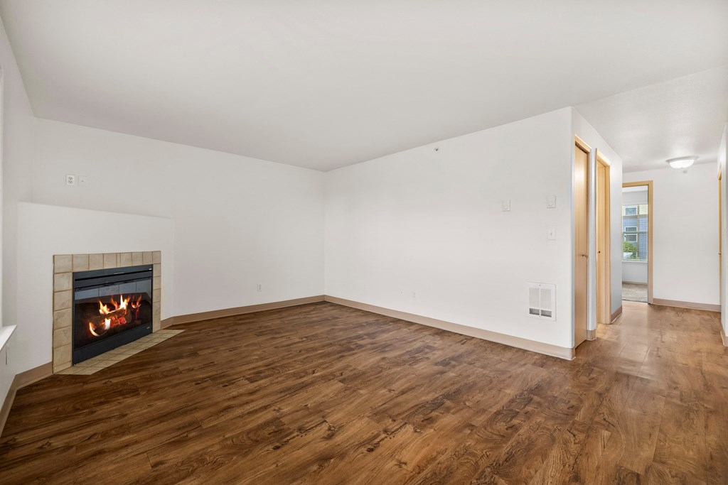 a living room with a fireplace and wooden floors