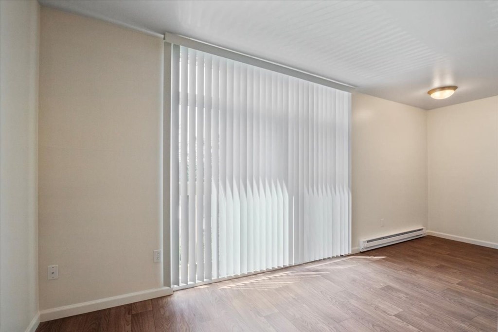 A room with a sliding door and wooden flooring.