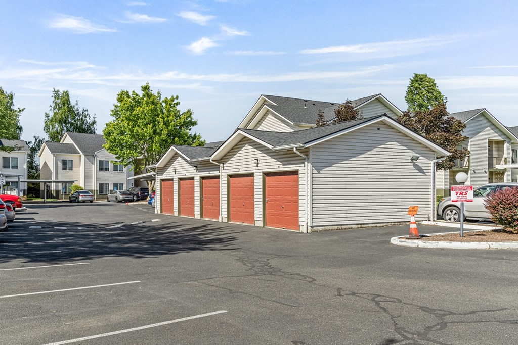 A parking lot with a building and a tree in the background.
