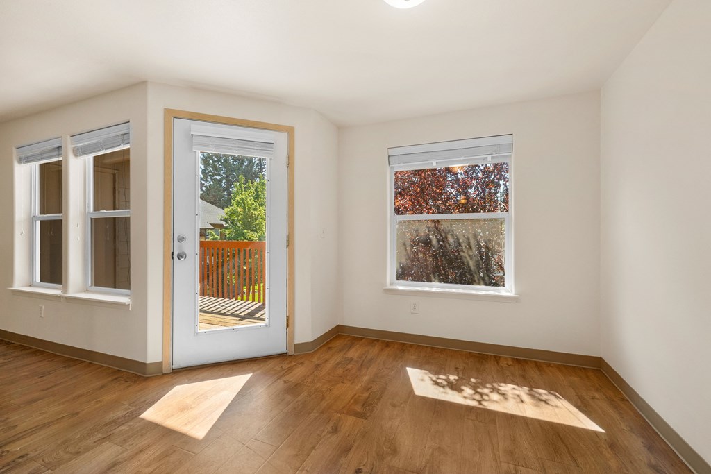 a living room with wood floors and a door to a balcony