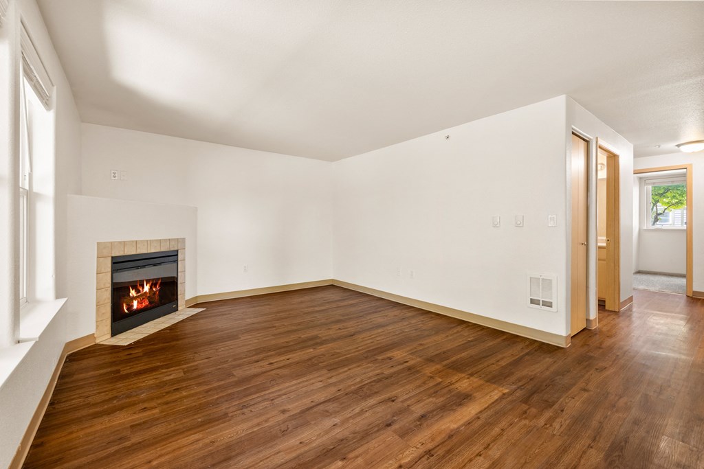 a living room with a fireplace and wooden floors