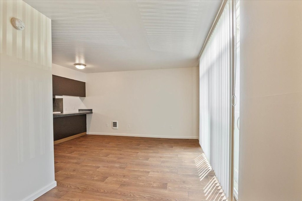 A room with wooden flooring and white walls.