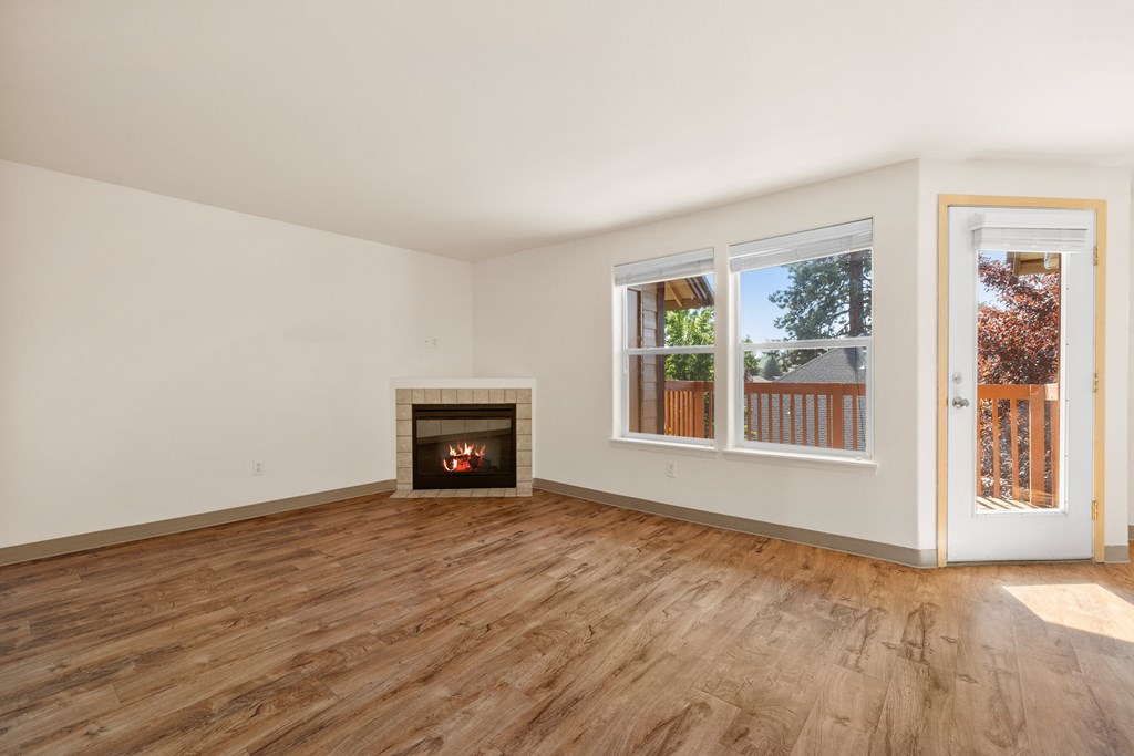 a living room with a fireplace and wooden floors
