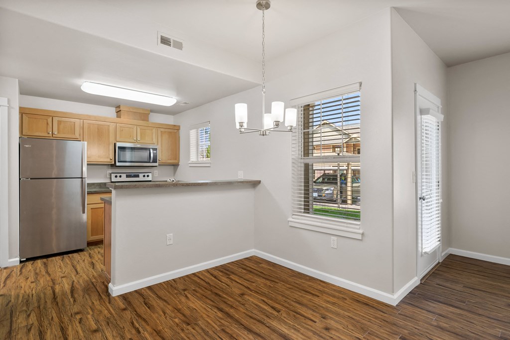 a kitchen with a large window and a stainless steel refrigerator