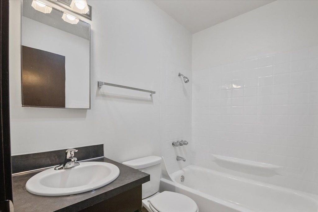 A white bathroom with a sink, toilet, and bathtub.