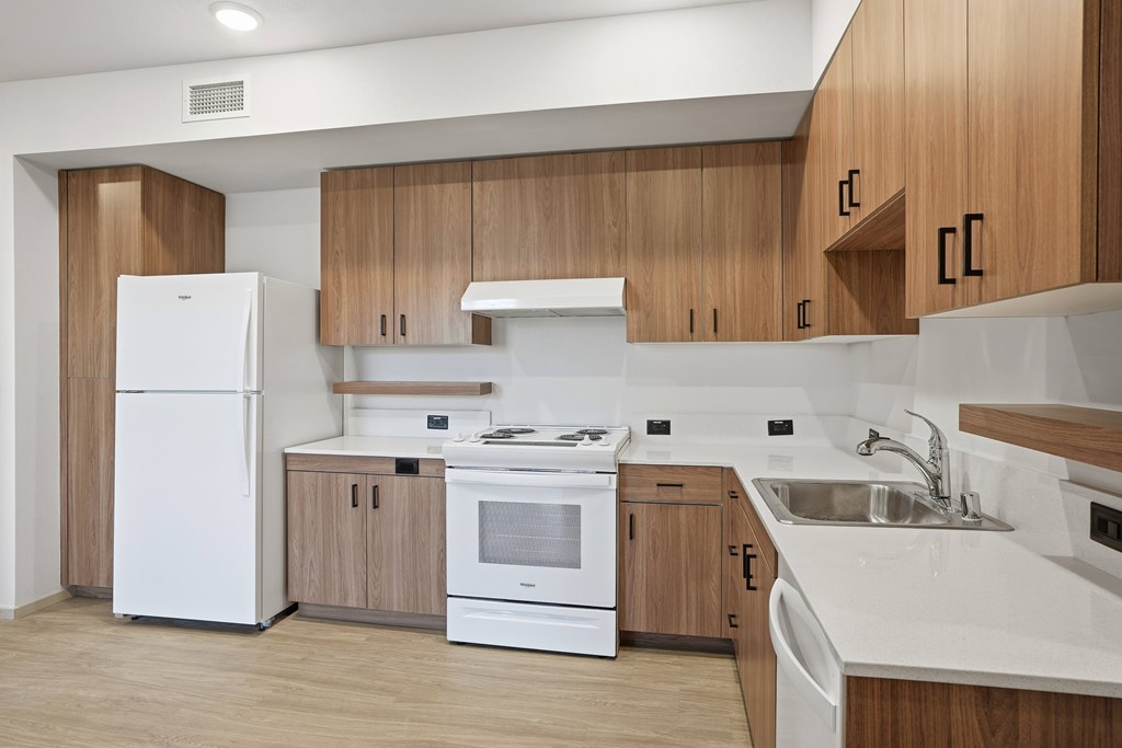A modern kitchen with wooden cabinets and white appliances.