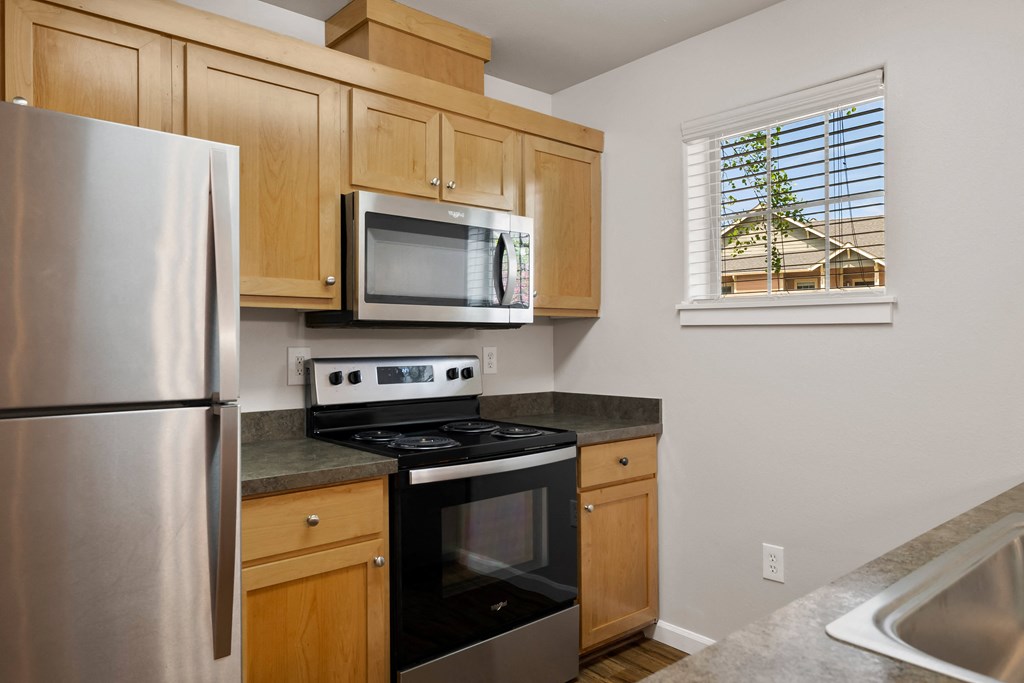 an updated kitchen with stainless steel appliances and wood cabinets