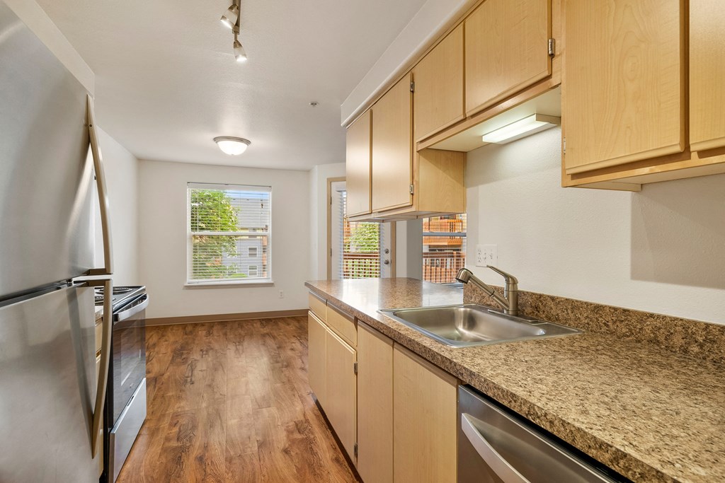 an empty kitchen with granite counter tops and stainless steel appliances