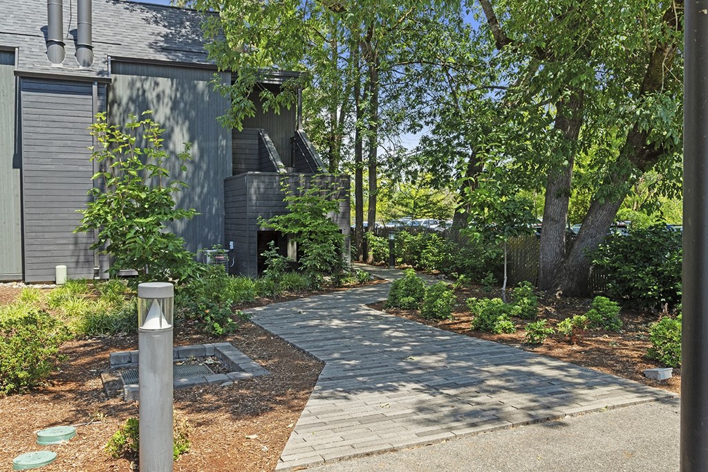 A grey building with a tree in front of it.