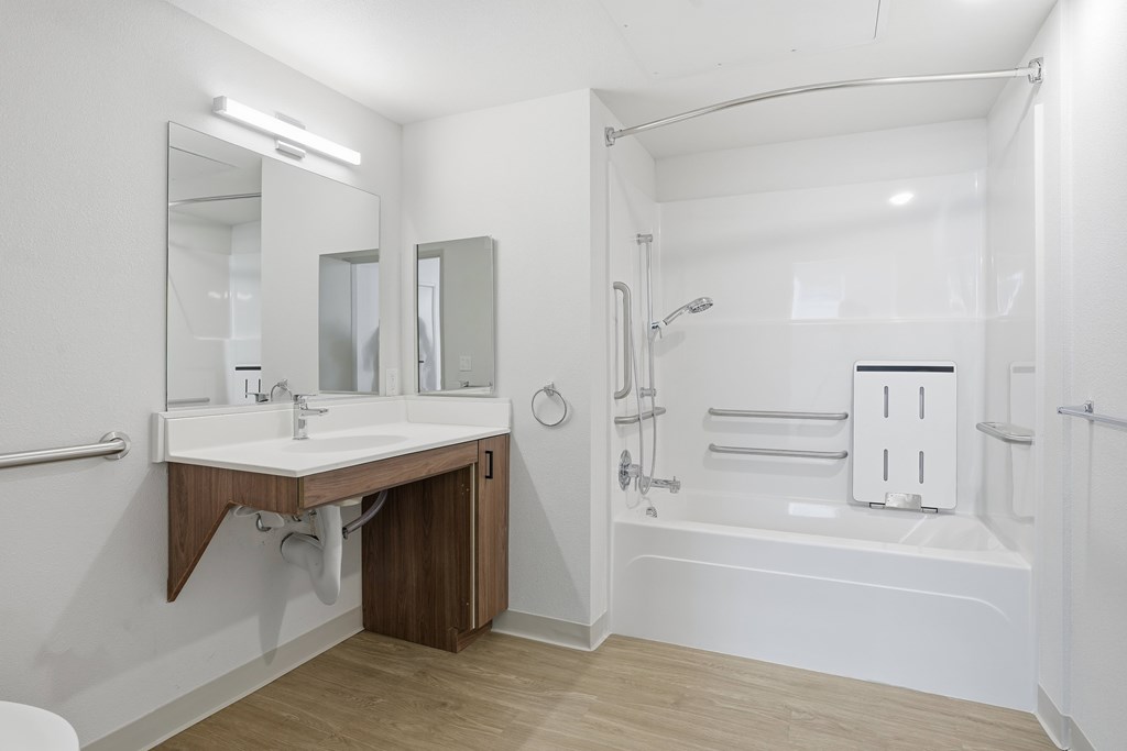 A white bathroom with a sink and a bathtub.