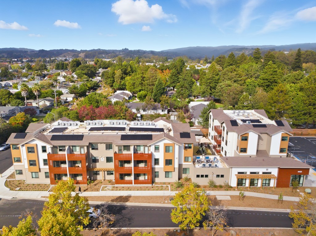 A large apartment complex with multiple buildings and a parking lot in front.
