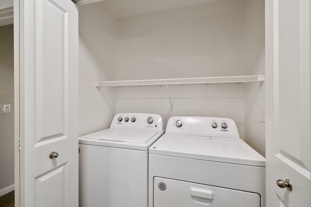 an empty laundry room with two washes and a dryer